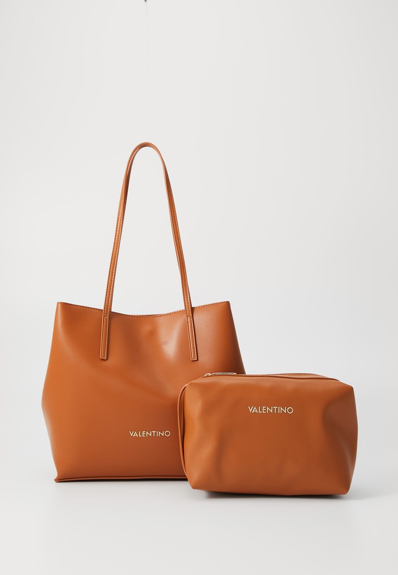 Brun lærveske med to lange håndtak, glatt tekstur og gull "Valentino"-logo. Inkluderer en matchende rektangulær kosmetikkveske.