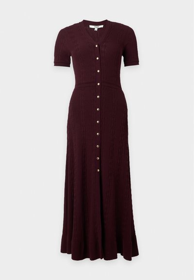 Robe en maille bordeaux foncé avec manches courtes, col en V, boutons dorés sur le devant et taille cintrée s’évasant en longue jupe.