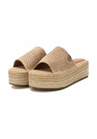Sandalias beige de tipo slip-on con parte superior perforada, amplia banda, plataforma envuelta en cuerda y suela de goma plana. Textura suave y diseño de punta abierta.