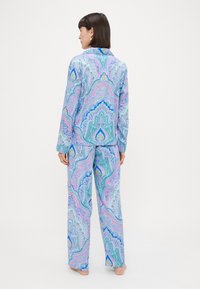 Set de pijama cu un model paisley albastru și roz, confecționat dintr-un material moale, având o bluză cu nasturi și pantaloni cu croi lejer și mâneci lungi.