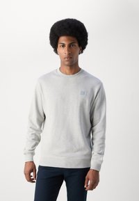 Gray sweatshirt made of soft fabric, featuring a round neckline, ribbed cuffs and hem, and a small square logo on the chest.