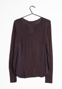 Top à manches longues en tissu texturé marron foncé ; comporte des panneaux latéraux contrastants, un col rond et un ourlet arrondi avec de légères fentes sur les côtés.