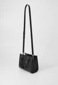 Sac à main en cuir noir avec une forme structurée, deux poignées et une bandoulière réglable. Comprend des accessoires en métal argenté et une finition texturée.