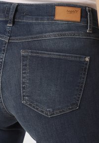 Dunkelblaue Jeans aus Denim mit einer Gesäßtasche, die eine subtile gestickte Kontur aufweist, und einem Lederetikett mit "Angels"-Branding oberhalb des Bundes.