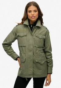 Chaqueta militar de color verde oliva con bolsillos frontales, hombreras y el detalle bordado de "LOVE". Cuenta con cierre de cremallera y botón.