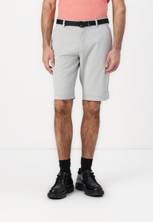Grå shorts med et subtilt rutemønster, rullet oppkant og et svart belte. Kombinert med svarte sko og mørke sokker.