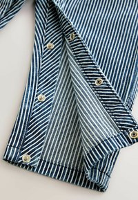 Gestreiftes blaues Denim-Hemd aus Stoff mit einer Knopfleiste, die abwechselnd schmale und breite Streifen zeigt. Die Textur ist weich und hat glänzende Metallknöpfe.