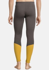 Grijze leggings met een strakke pasvorm en een gele accent aan de onderkant van het been. De stof heeft een gladde textuur, geschikt voor actieve kleding.