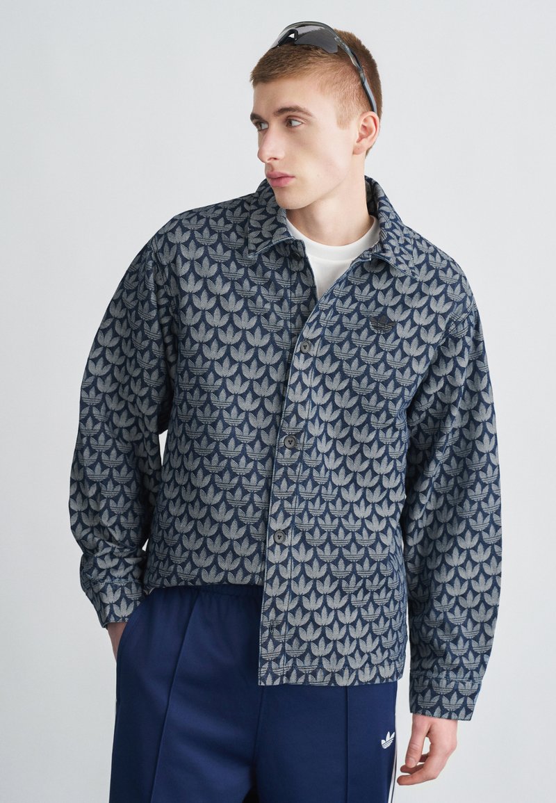 Srajca z gumbi z modrim in sivim vzorcem listov, narejena iz teksturirane tkanine, z nazobčanim ovratnikom in dolgimi rokavi.