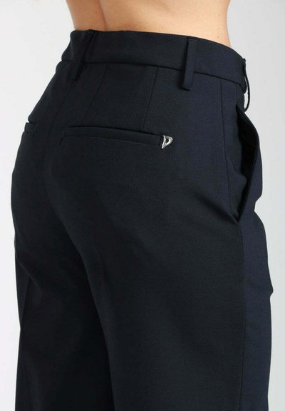 Pantaloni neri in tessuto liscio, con vita aderente, tasche laterali e un piccolo dettaglio argentato sulla tasca posteriore.