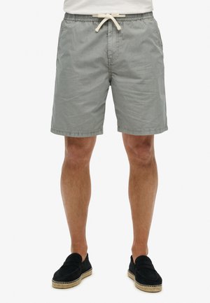 Shorts en coton gris clair, arrivant au genou, avec une taille élastique et un cordon de serrage. Texture lisse avec des poches latérales.