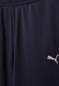 Σκούρες μπλε φόρμες από μαλακό ύφασμα με ελαστική μέση και πλαϊνές τσέπες. Διαθέτουν ένα μικρό, κεντητό λογότυπο Puma σε ανοιχτό χρώμα.