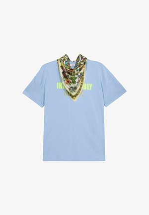 Tricou din bumbac de culoare albastru deschis, cu mâneci scurte, prezentând o grafică imprimată în galben neon și o eșarfă atașată cu un model în nuanțe de verde și galben.