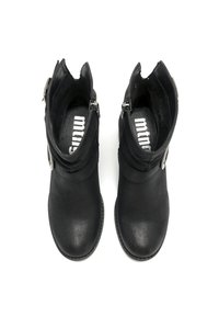 Une paire de bottines noires à cheville avec des orteils ronds, des boucles latérales et un logo blanc visible à l'intérieur, montrées de vue de dessus sur fond blanc.