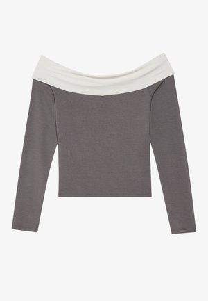 Nuoga pečių ilgomis rankovėmis palaidinė su pilku kūnu ir baltu apykakle. Lygus paviršius ir prigludęs dizainas.