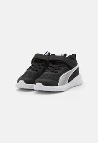 Chaussures de sport noires en matériau en mesh, avec une semelle blanche et un panneau rayé contrastant. Elles comprennent des lacets et une sangle Velcro.