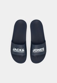 Marineblaue Slides mit mattem Finish und strukturiertem Fußbett, mit weißer Markenaufschrift "JACK & JONES" auf den Riemen.