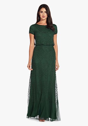 Grünes Abendkleid mit kurzen Ärmeln, einer taillierten Oberseite und einem fließenden Rock mit aufwendigen, bestickten Wellenmustern. Transparente Überlagerung am unteren Rand.