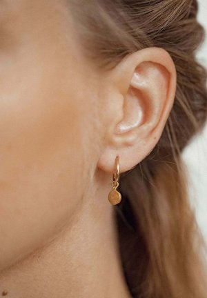 Goldene Creolen mit einem kleinen, strukturierten runden Anhänger, der von der Creole hängt. Die Ohrringe zeigen ein poliertes Finish und ein minimalistisches Design.