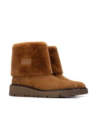 Botas de tobillo de ante marrón con un cómodo puño de piel sintética, suela de goma texturizada y un pequeño parche con el logo en el lado exterior.