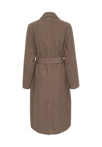 Brūns vilnas maisījuma mētelis ar garām piedurknēm, izgriezumu apkakli un jostu vidukļa daļā. Tam ir taisna piegriezuma forma un aizmugures atvere ērtākai kustībai.