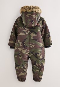 Kamuflāžas snowsuit ar mākslīgā kažokādas apdari kapuci, elastīgām aprocēm un ūdensizturīgu materiālu zaļās, brūnā un melnās krāsās.