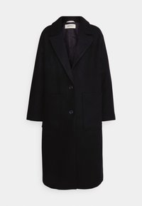 Manteau noir longueur genoux avec revers, deux poches avant et fermeture à boutons. Fabriqué en tissu doux et texturé avec une silhouette droite.