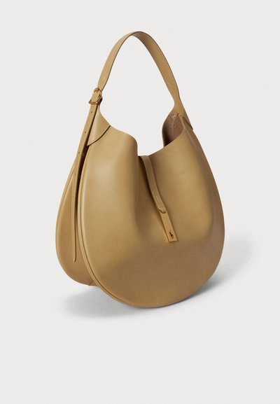 Torba hobo u svijetlo smeđoj koži s zakrivljenim oblikom, ravnim remenom i zatvaračem sa zlatnim detaljem. Glatka tekstura i minimalistički dizajn.