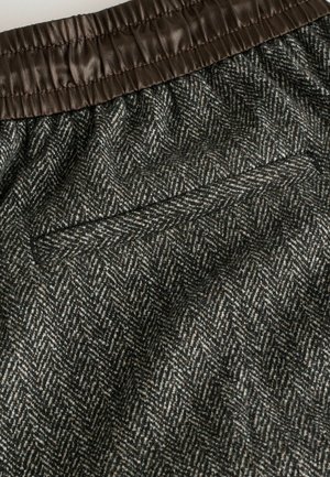 Szövött szövetből készült rövidnadrág barna elasztikus derékpánttal, amelyben halszálkamintás szürke és krémszínű árnyalatok dominálnak, egyetlen hátsó zsebbel.