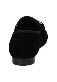 Scarpa in velluto nero con tacco basso, caratterizzata da un accento dorato sul lato, texture liscia e design con retro arrotondato.