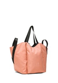 Iso pehmeä persikanvärinen olkalaukku, jossa mustat kahvat, vetoketjullinen aukko ja etuosassa "DEHA"-logo, esitetty valkoista taustaa vasten.