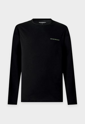 Schwarzes Langarm-Emporio Armani-Shirt mit kleinem weißem Logo auf der linken Brust, Rundhalsausschnitt und schlichtem Design auf hellem grauem Hintergrund.