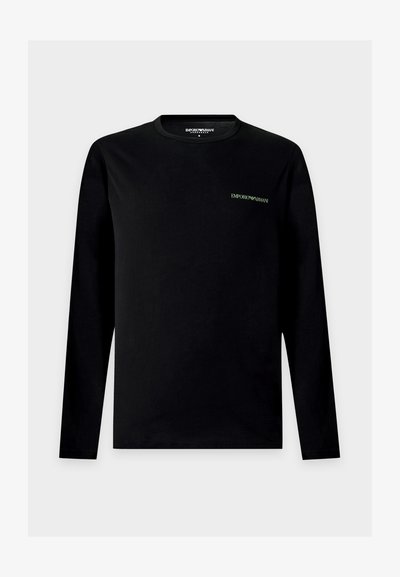 Μαύρο μακρυμάνικο πουκάμισο Emporio Armani με μικρό λευκό λογότυπο στο αριστερό μέρος του στήθους, στρογγυλή λαιμόκοψη και απλό σχέδιο σε ανοιχτό γκρι φόντο.