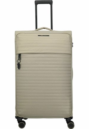 Maleta beige de caparazón blando con acolchado horizontal, asa telescópica extendida, bolsillo frontal con cremallera y cuatro ruedas giratorias negras.