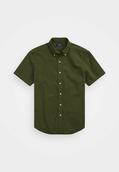 Košulja kratkih rukava, na dugme, u tamnozelenoj boji od pamuka s klasičnim ovratnikom i malim izvezenim logom na prsima. Jednostavna tekstura, redovita kroja.