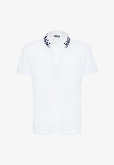 White short-sleeve polo shirt with buttoned placket and gradient collar featuring bold black "EMPORIO ARMANI" text.