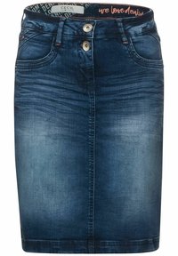 Jeanskjol i mörkblå färg. Har två framfickor, knappstängning och kontrasterande sömmar. Slät yta med en figurnära passform.