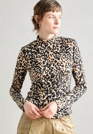 Langermet rollkragegenser i et leopardmønster med en beige bakgrunn og svarte prikker, laget av myk, teksturert stoff.