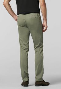 Slim-fit, olijfgroene broeken met een gladde textuur, twee achterzakken met decoratieve stiksels en een klassieke tailleband, gecombineerd met donkere schoenen.