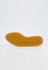 Semelle de chaussure, matériau en caoutchouc, couleur jaune, texturée avec des rainures horizontales, orteil arrondi, zone de talon lisse, design plat.