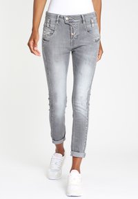 Grijze denim jeans met een taps toelopende pijp, opgerolde manchetten, voorzakken en accentdetails van messing knopen. Licht vervaagd met een zachte textuur.