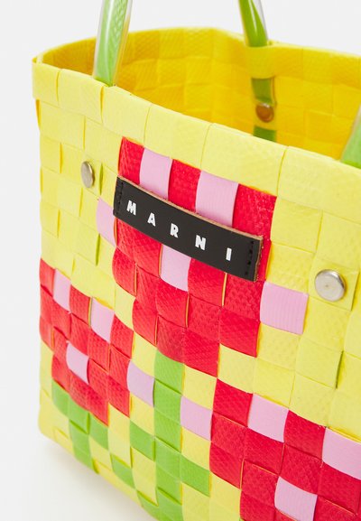Sacola de malha em amarelo, vermelho, verde e rosa em plástico. Apresenta um rótulo preto com "MARNI" e duas alças verdes. Superfície texturizada.