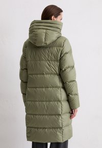 Olijfgroen pufferjack met een capuchon, voorzien van horizontale gestikte secties en een knielange snit. Glad oppervlak en stevig materiaal.