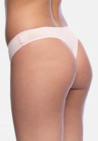 Helle rosa Tanga-Unterwäsche aus glattem Stoff, mit minimalistischer Gestaltung und einem zarten elastischen Bund mit feinen Nähten.