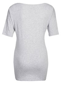Camiseta gris de manga corta hecha de una suave mezcla de algodón; presenta un corte relajado y un escote amplio; textura lisa con detalles de diseño mínimos.