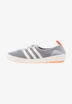 Zapatilla deportiva gris claro con parte superior de malla, rayas y suela blancas, lengüeta del talón naranja y suela exterior naranja, con la marca climacool en el lateral.