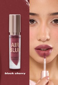 Myk matte flytende leppestift i "Black Cherry", med en klar beholder og et metallisk roségull lokk. Applikatoren er myk og avsmalnet for presis påføring.