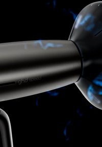 Sèche-cheveux noir avec des étincelles électriques bleues autour de la buse et le logo "ghd speed" sur la poignée.