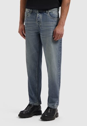 Light blue denim jeans with a relaxed fit, featuring a faded wash, five pockets, belt loops, and stitched detailing at seams.