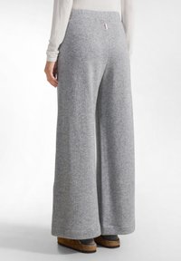 Grijze wijde pantalon gemaakt van zachte stof; subtiele textuur; elastische tailleband; bevat een klein gelabeld etiket op de achterkant.